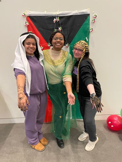 3 students dressed in traditional Kuwaiti outfits