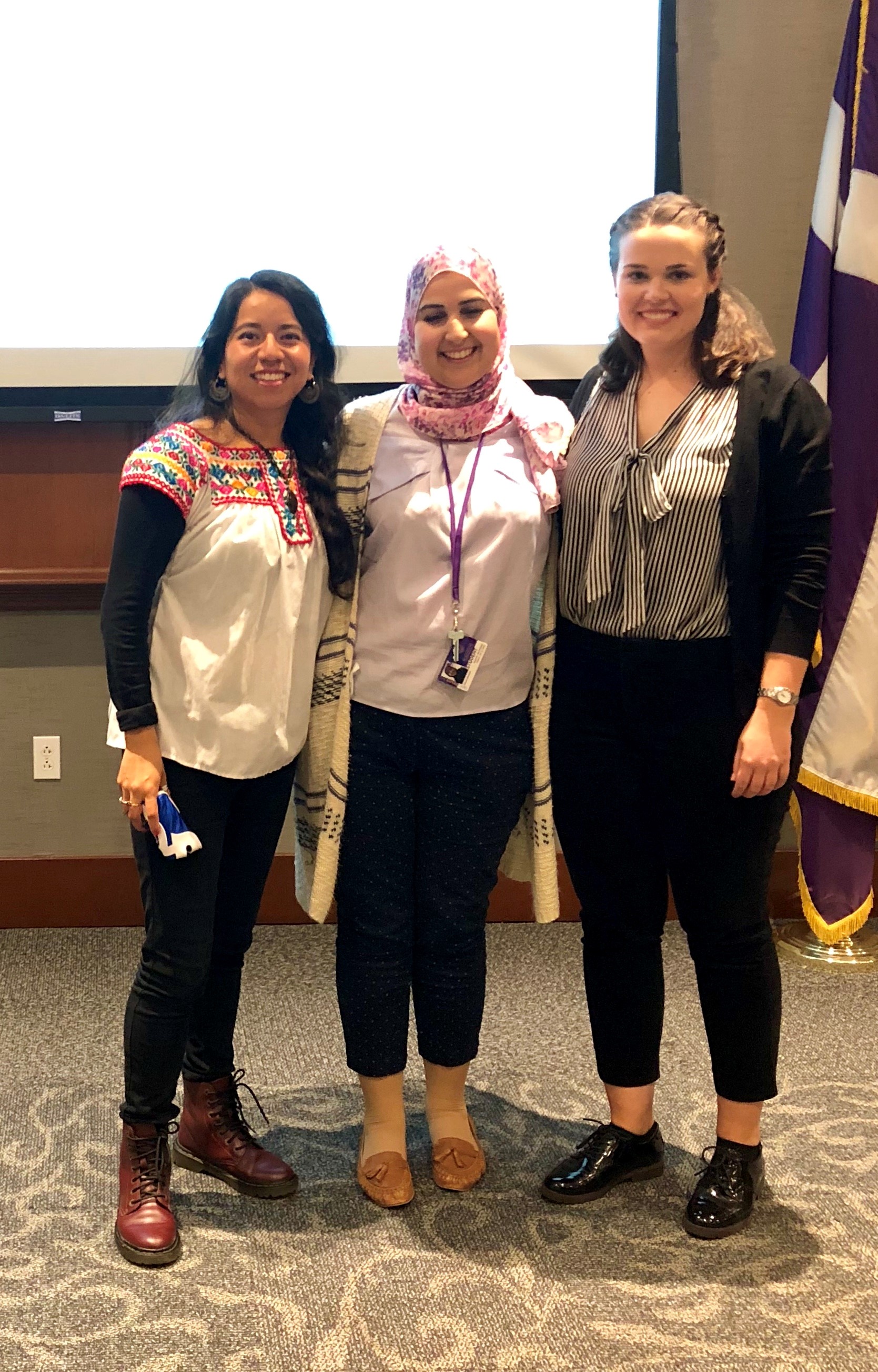 Vianey Florentino Perez, Rabab Mesbahi, and Lea Gorski standing in front of a screen and University of Scranton flag.