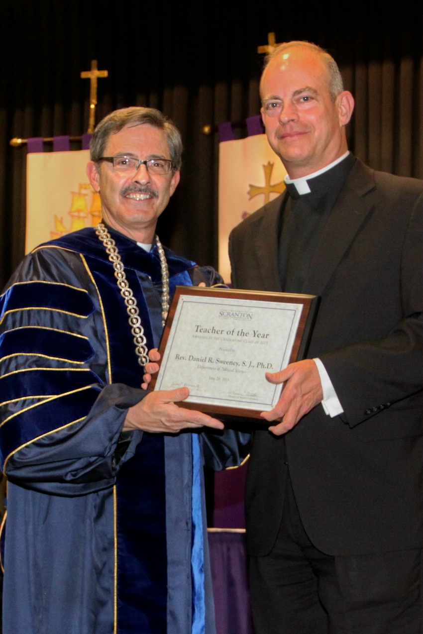 From left: University of Scranton President Kevin P. Quinn, S.J., presents Daniel R. Sweeney, S.J., assistant professor of political science, with the Teacher of the Year award on behalf of The University of Scranton’s class of 2015. 
