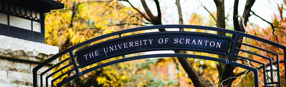 Arch that says "University of Scranton" with fall foliage in the background. 