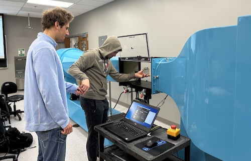 Two male students work on an experiment with a wind tunnel in the mechanical engineering lab at The University of Scranton 