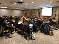 An auditorium of people listening to Dr. Neguerela