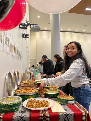 Students grabbing Kuwaiti sweets from table