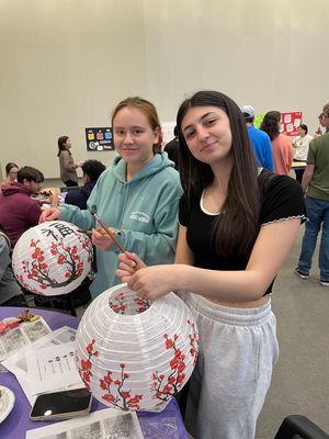 2 students holding up paper lanterns