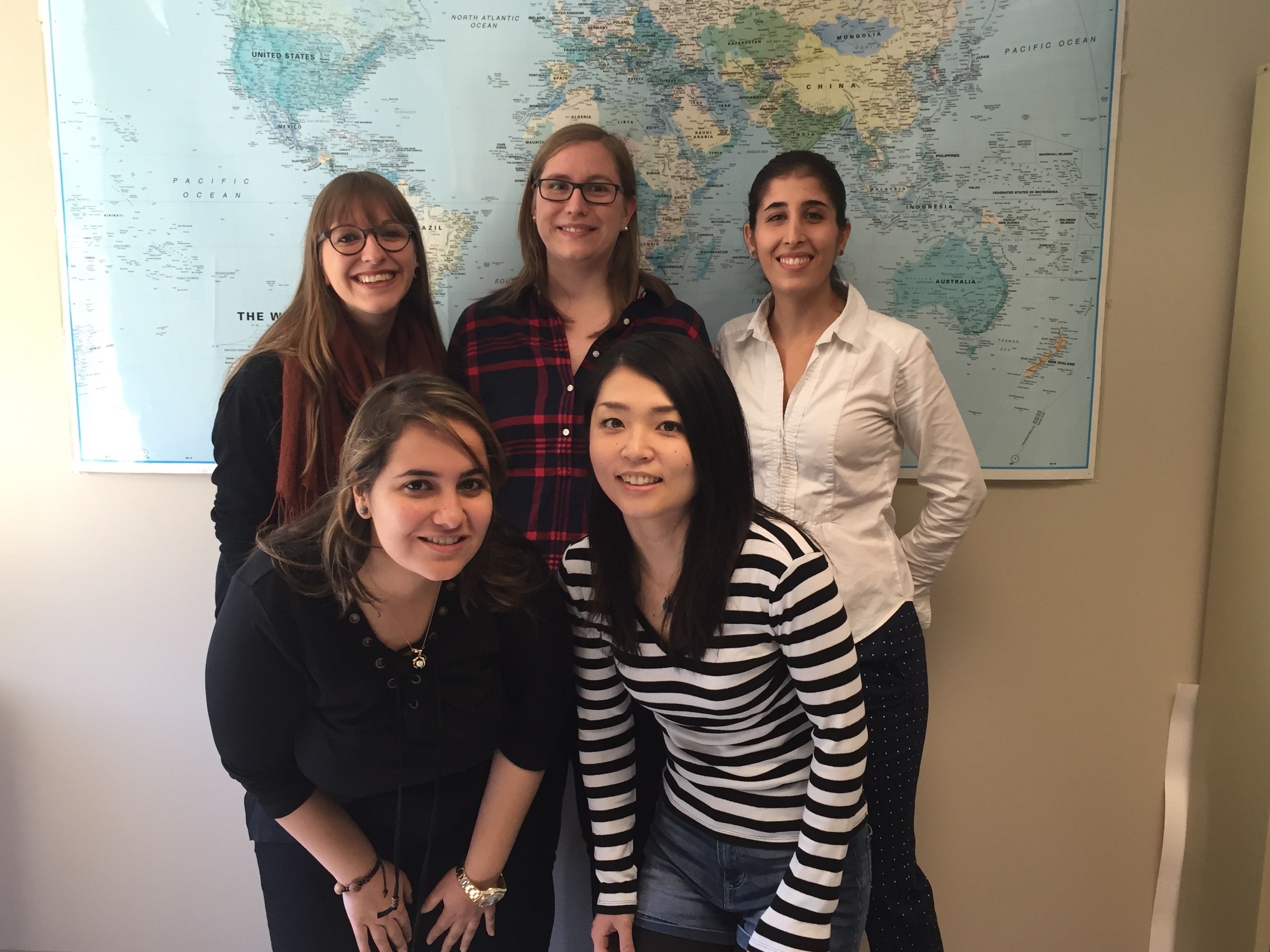 Celine Langlard, Sarah Schreier, and Carmen Cespedes Suarez standing in the back with Aymen Khazaal and Chie Fujikake standing in front of them with a map behind them.