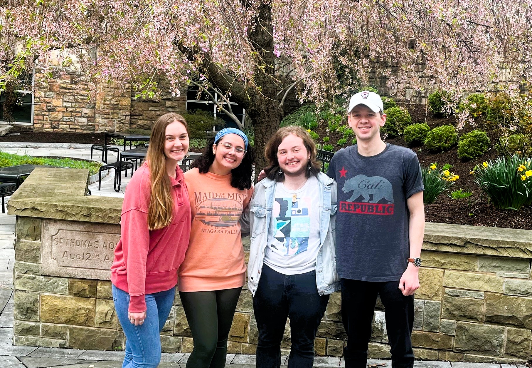 Four writing tutors in front of the library