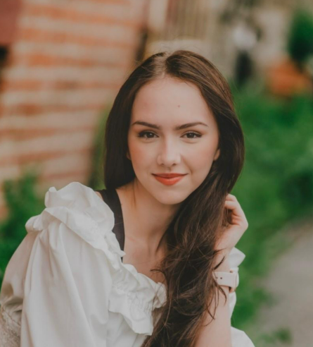 A girl with dark hair in a white blouse 