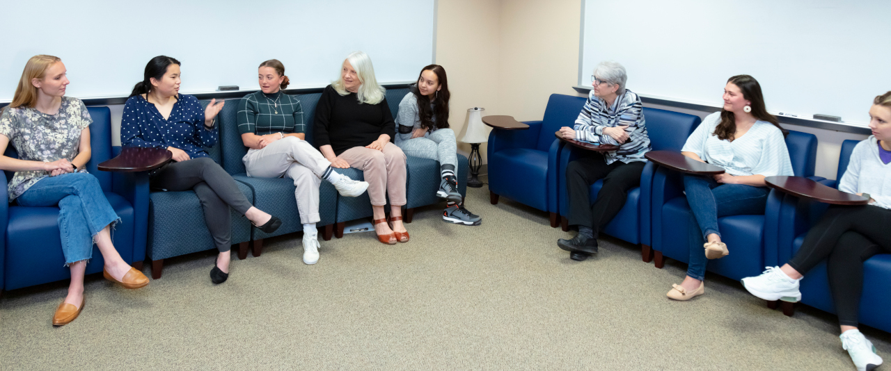 Two Counseling and Human Services professors conduct a class with several female students in the Counselor Training Center at The University of Scranton 
