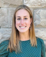 A young woman with long blond hair wearing a green blouse.
