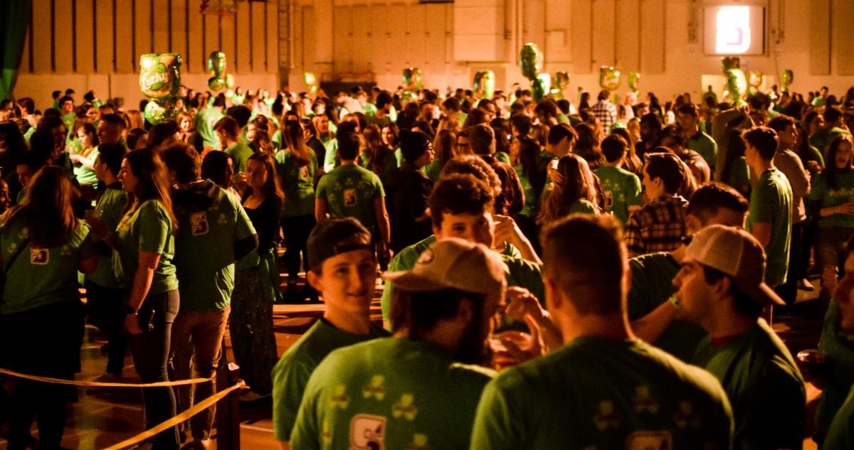 Large group of students and alumni at Shamrockin Eve dressed in green T-Shirts